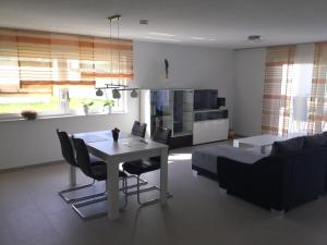 cocina y sala de estar con mesa y sofá en Apartment Am Etzelbach, en Balingen