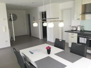 una cocina con una mesa blanca con un jarrón de flores. en Apartment Am Etzelbach, en Balingen