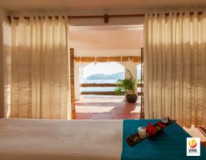 een slaapkamer met een bed en uitzicht op de oceaan bij Hotel Irma in Zihuatanejo