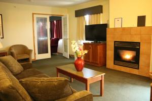 a living room with a couch and a fireplace at Nomad Hotel & Suites in Fort McMurray