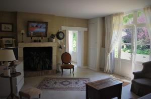 a living room with a fireplace and a chair at Le clos des Acanthes in Vouvray