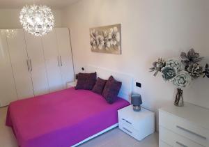 a bedroom with a pink bed and a chandelier at Apartment Chuck in Krk