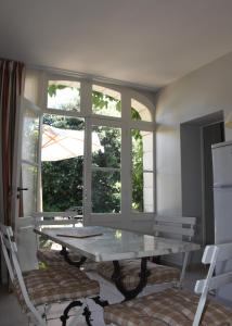 a table and chairs in a room with a window at Le clos des Acanthes in Vouvray