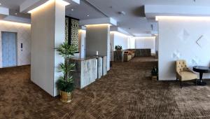 an office lobby with a hallway with plants in it at Sedra Residence in Kuwait +102 photos