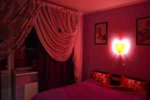 sypialnia z łóżkiem z oświetleniem serca w obiekcie Apartments on Duki w mieście Briańsk