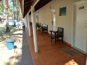 a porch of a house with chairs and a table at Apartamento Campo Belo in Álvares Machado