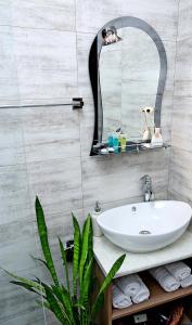 Un baño con un lavabo blanco y un espejo. en Tbilisi Trinity Apartment, en Tiflis