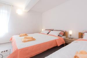 Un dormitorio con dos camas con toallas encima. en Apartman Marija 218, en Risika