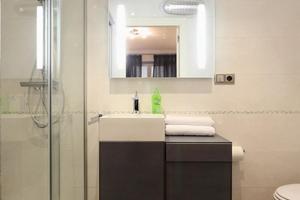 a bathroom with a sink, mirror and toilet at Flatsforyou Sorolla House in Valencia