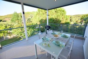 a white table and chairs on the balcony of a house at Vista Luxury Suites Toroni Halkidiki 1BR in Toroni