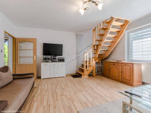 a living room with a staircase and a television at Domek nad Kanałem Łuczańskim in Giżycko