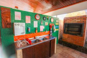 a kitchen with a sink and a brick fireplace at Hotel Hostel Caçari in Boa Vista