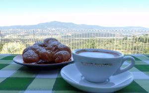 Una taza de café y dos donuts en una mesa. en B&B La Casa del Sarto, en Città della Pieve