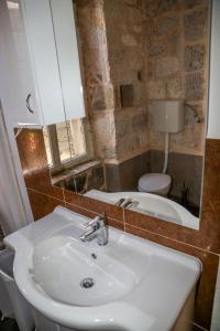 La salle de bains est pourvue d'un lavabo, de toilettes et d'un miroir. dans l'établissement Hvar Piazza Apartment, à Hvar