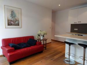 a living room with a red couch and a kitchen at Wolfshaegen 180 in Huldenberg