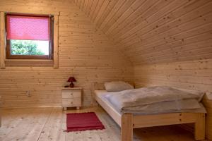 a bedroom with a bed in a wooden room at Domki Wczasowe Mielenko in Mielenko