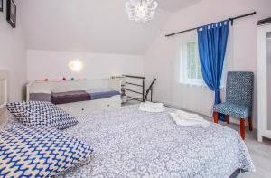 une chambre avec un lit et une chaise dans l'établissement Lawendowe domki apartamenty, à Władysławowo