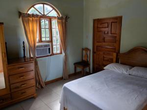 1 dormitorio con cama y ventana en Barhanna Vista Lodge, en Port Antonio