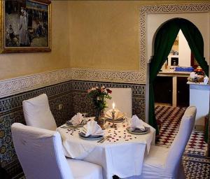 una mesa con un mantel blanco y una vela en Riad Bab Chems, en Marrakech
