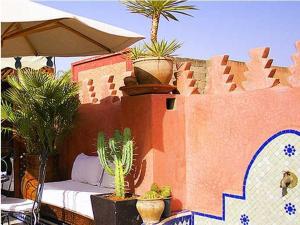 patio con piante in vaso su un muro di Riad Bab Chems a Marrakech