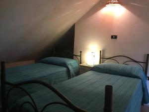 ein Schlafzimmer mit 2 Betten und einer Lampe an der Wand in der Unterkunft Residence Lithos in Petralia Soprana