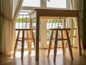 drewniany stół i dwa stołki przed oknem w obiekcie Pokoje U Solany w mieście Knurów