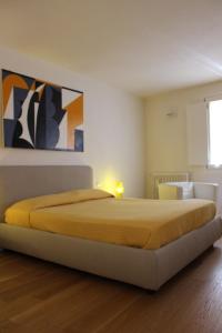 a bedroom with a large bed with a yellow blanket at Dimora di Charme Cassaro 168 in Marsala