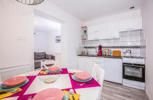 une cuisine et une salle à manger avec une table et des chaises dans l'établissement Lawendowe domki apartamenty, à Władysławowo