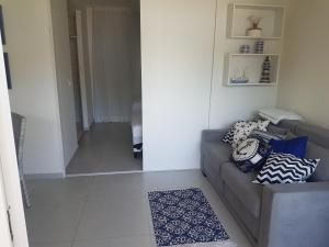 a living room with a couch and a hallway at Solar Água - Apto. 114 in Pipa +10 photos