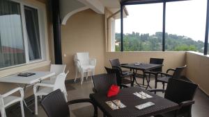 a restaurant with tables and white chairs and windows at Villa Royal House in Makhinjauri