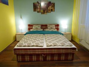 a bedroom with a large bed with two lamps on both sides at Eper Apartman in Debrecen