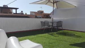 a table and chairs and an umbrella on a patio at Pension Centro in Guardamar del Segura
