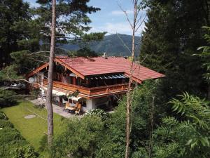 ein Haus mit rotem Dach im Wald in der Unterkunft Ferienwohnung am Römerweg Wald in Inzell