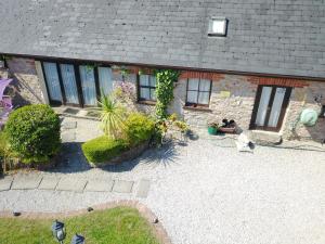 a cat sitting in front of a brick house at Mill Cottage in Paignton