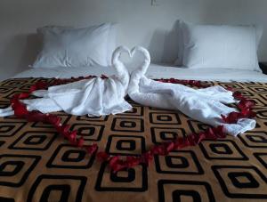 a bed with white sheets and a white blanket on top of it at Mongui Plaza Hotel in Monguí
