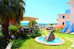 a garden with a rock in the grass at Asteras Apartments in Xerokampos