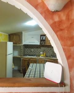 una cocina con un arco sobre una mesa con un ordenador portátil en Casa Aurora en Dorgali