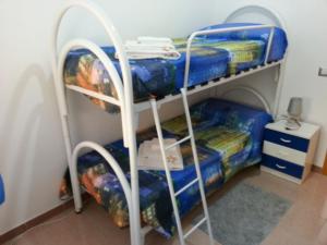 a bunk bed in a room with blue sheets at Villa Fiorella in Sciacca
