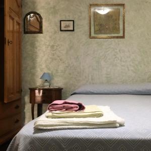 1 dormitorio con 1 cama con 2 toallas en Casa Aurora, en Dorgali