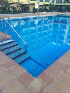 a large swimming pool with stairs next to a building at Apartment Yumbo Centrum in Playa del Ingles