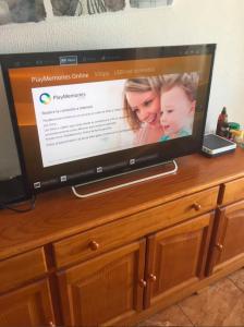 a flat screen tv sitting on top of a wooden cabinet at Apartment Yumbo Centrum in Playa del Ingles