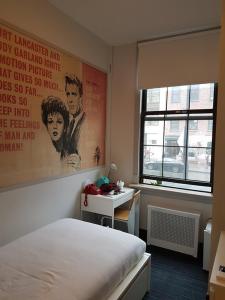 a room with a bed and a desk and a window at Chelsea Pines Inn in New York