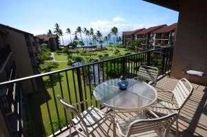 a patio with a table and chairs on a balcony at Papakea #H401 in Lahaina