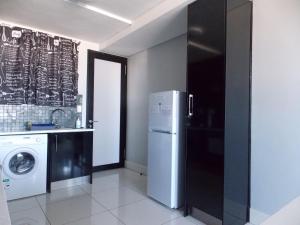 a kitchen with a refrigerator and a washing machine at Unit 46 @ 77 on Independence in Windhoek