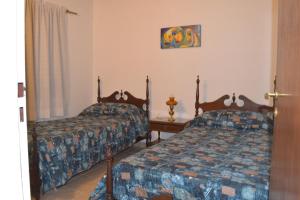 Un dormitorio con dos camas y una mesa. en Apartamento La Felicidad, en Tandil