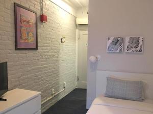a white room with a bed and a brick wall at Chelsea Pines Inn in New York