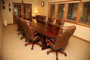 Corporate East Hotel في Ulysses: قاعة اجتماعات مع طاولة وكراسي