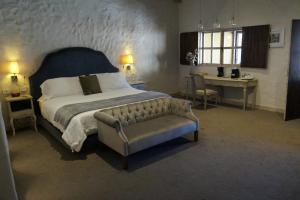 a bedroom with a large bed and a couch at Hotel Canaria in Santeagueda