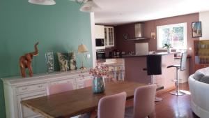 eine Küche mit einem Tisch und einer Blumenvase darauf in der Unterkunft Ma Maison Familiale Portesienne in Portets