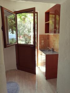 una cocina con una puerta que da a una cocina con ventana en Piqeras Relax Guest House, en Piqeras